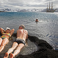 Tourists bathing in natural hot tub with volcanically heated water at Pendulum Cove, Deception Island, South Shetland Islands, Antarctica