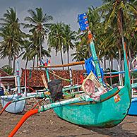 Colourful Indonesian jukungs, traditional wooden outrigger canoes on the Madewi beach along the Indian Ocean, Bali, Indonesia