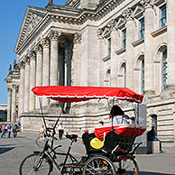 Taxi bike / rickshaw in front of the Reichstag building / Reichstag at Berlin, Germany