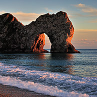 Durdle Door, a natural limestone arch at sunset along the Jurassic Coast near West Lulworth in Dorset, southern England, UK
