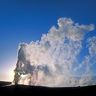 Old Faithful geyser erupting at sunset, Yellowstone National Park, Wyoming, USA 